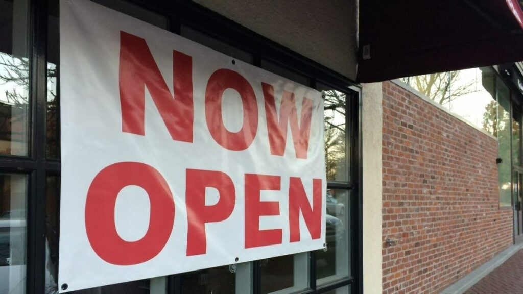 custom vinyl banner reading "now open"