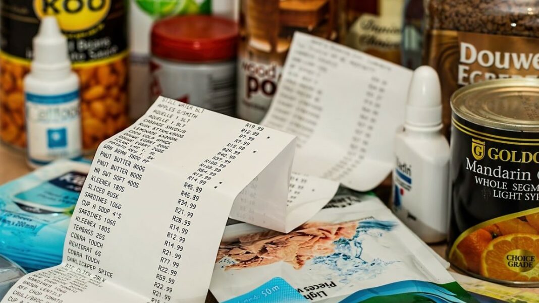 debt and inflation represented by cash register tape and some groceries on a counter