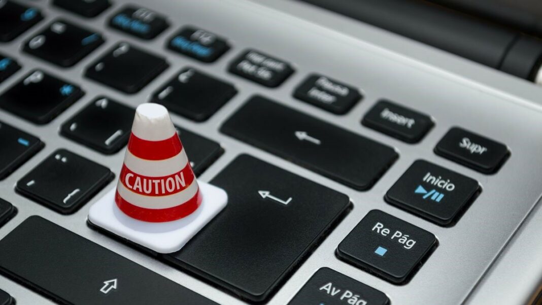 IAM solutions represented by a white caution cone on a computer keyboard