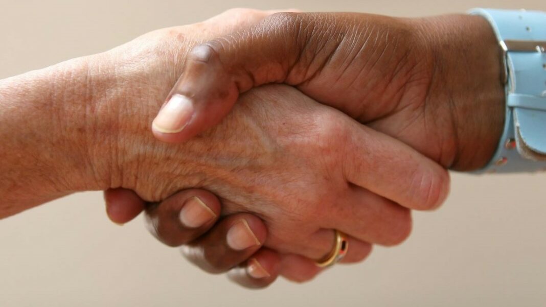 employment law compliance represented by the hands of two people shaking hands