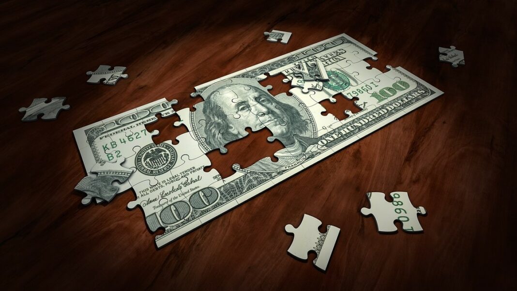 money management represented by a jigsaw puzzle of the image of a US one-hundred-dollar bill