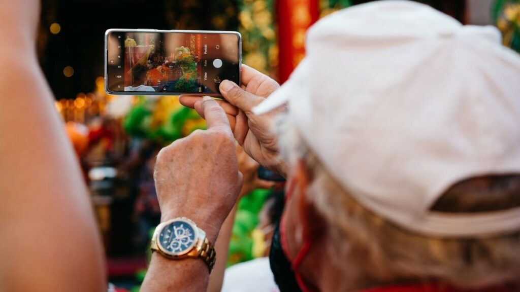mobile video represented by a colorful photo of a man wearing a white cap taking a video with a smartphone