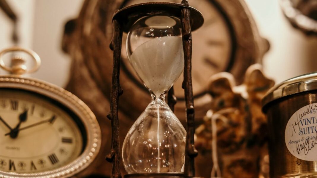 getting better at time management represented by photo in sepia tones of vintages timepieces, including a clock, a watch, and an hourglass
