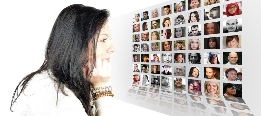 Woman facing screen with grid view of multiple customer interactions