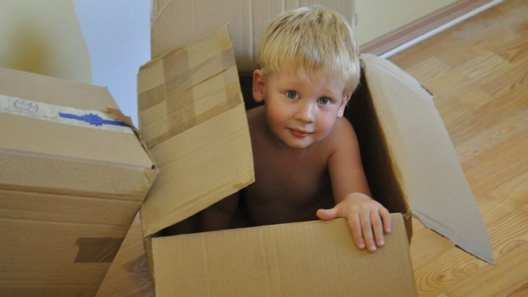 moving boxes represented by a child playing with empty boxes