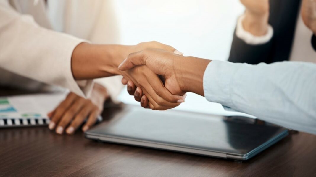 onboarding represented by people shaking hands in a corporate setting