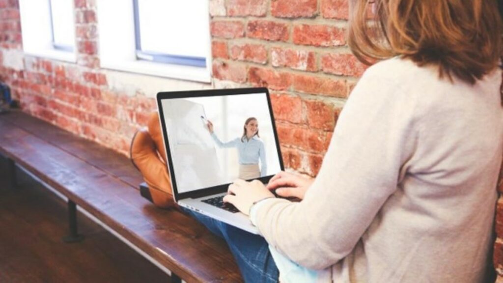 onboarding process represented by a woman viewing a video on a laptop