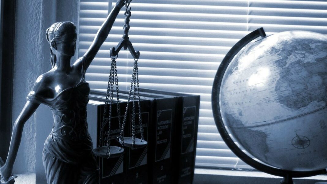 law firms represented by a black-and-white photograph of a statue of Lady Justice next to some law textbooks and a globe