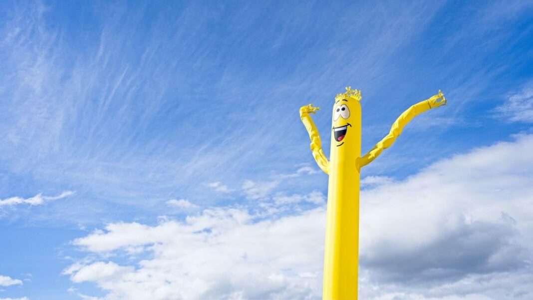 offline marketing represented by yellow inflatable tube man with a happy face dancing in the wind