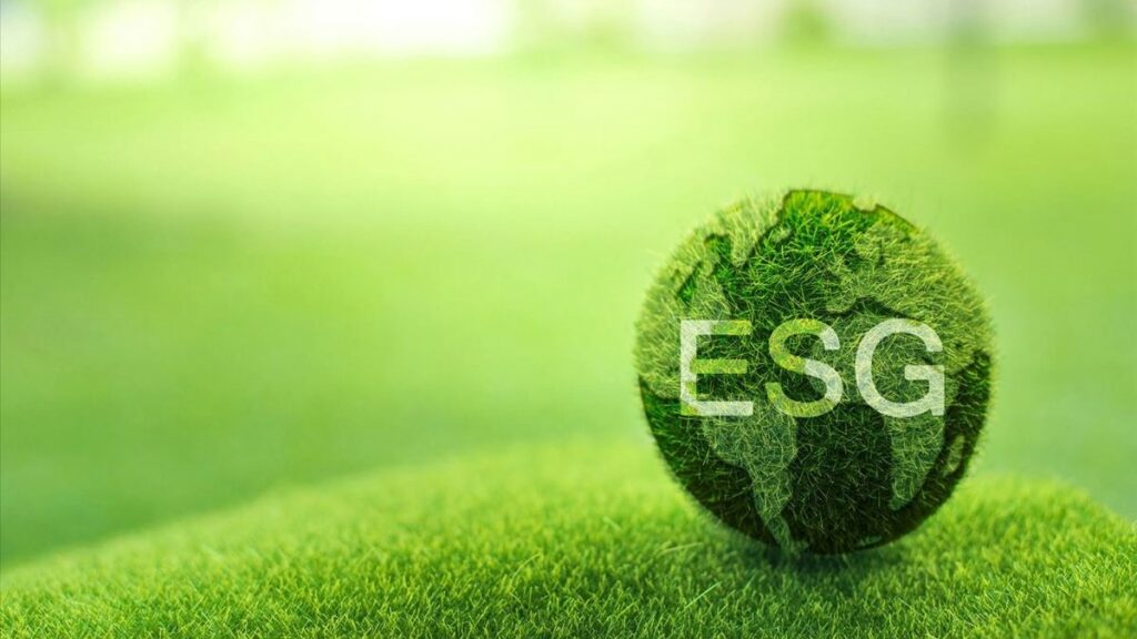 ESG employment represented by a green globe with the letters "ESG" written on it resting on a green field