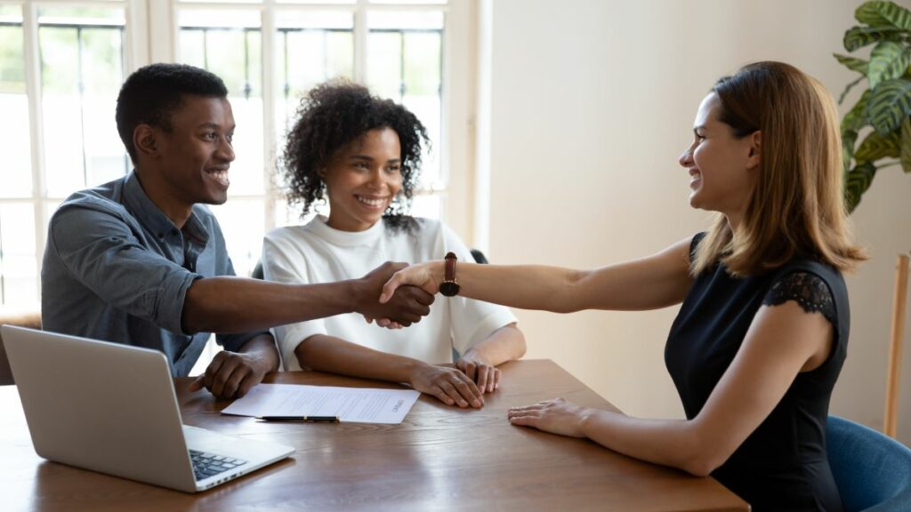 mortgage crm represented by a happy young couple shaking hands with a mortgage broker