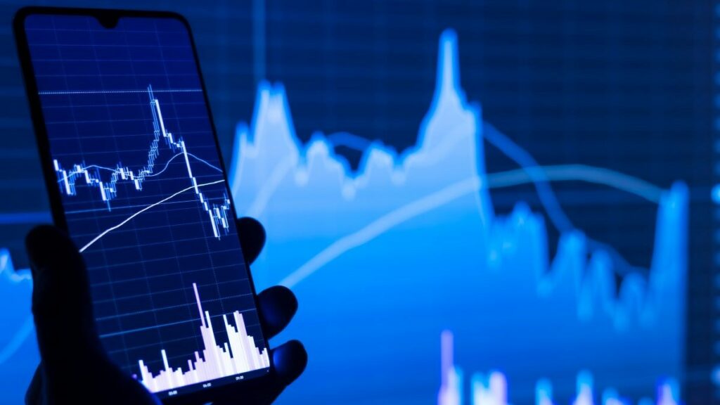 turnkey technology represented by a person's hand holding a cell phone in front of a stock chart