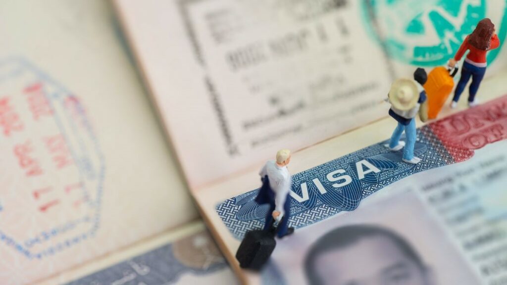 American expatriates represented by miniature toys in a studio setup with a visa on a passport as background