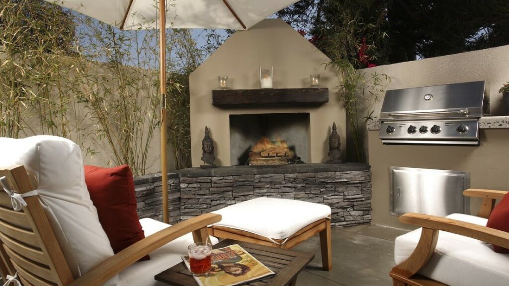 a backyard with built-in firepit, gas grill, and comfortable chairs