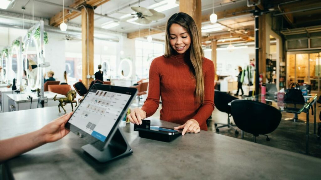 f&b (food and beverage) establishments represented by a smiling woman making a payment using a credit card reader