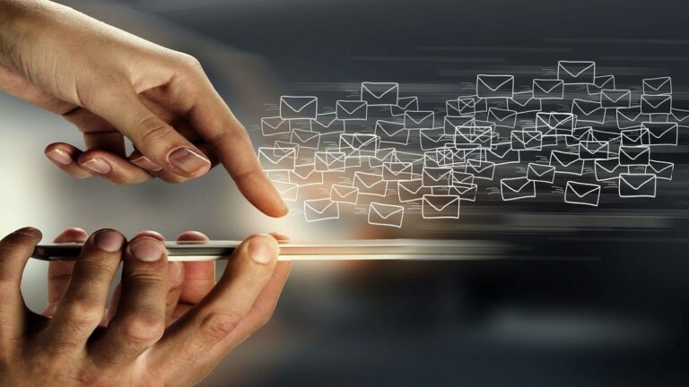 email api represented by two hands near a device screen with icons of emails floating away from it