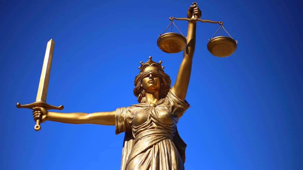 personal injury law firm represented by a photo of a statue of Lady Justice against a royal blue background